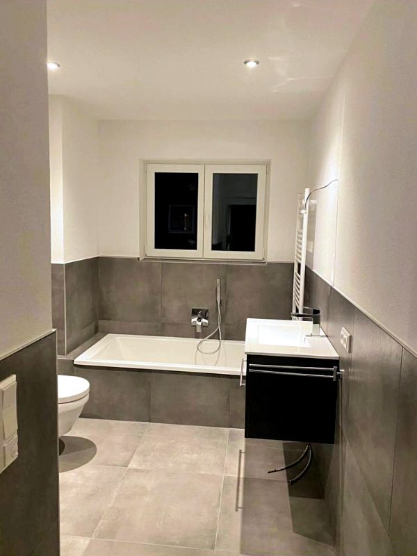 Badezimmer mit Badewanne, Waschbecken und WC nach Renovierung in Ingolstadt von Renovierung & Sanierung ALBAN